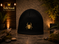 Black SilkNook beanie featuring a gold embroidered jumping spider logo.